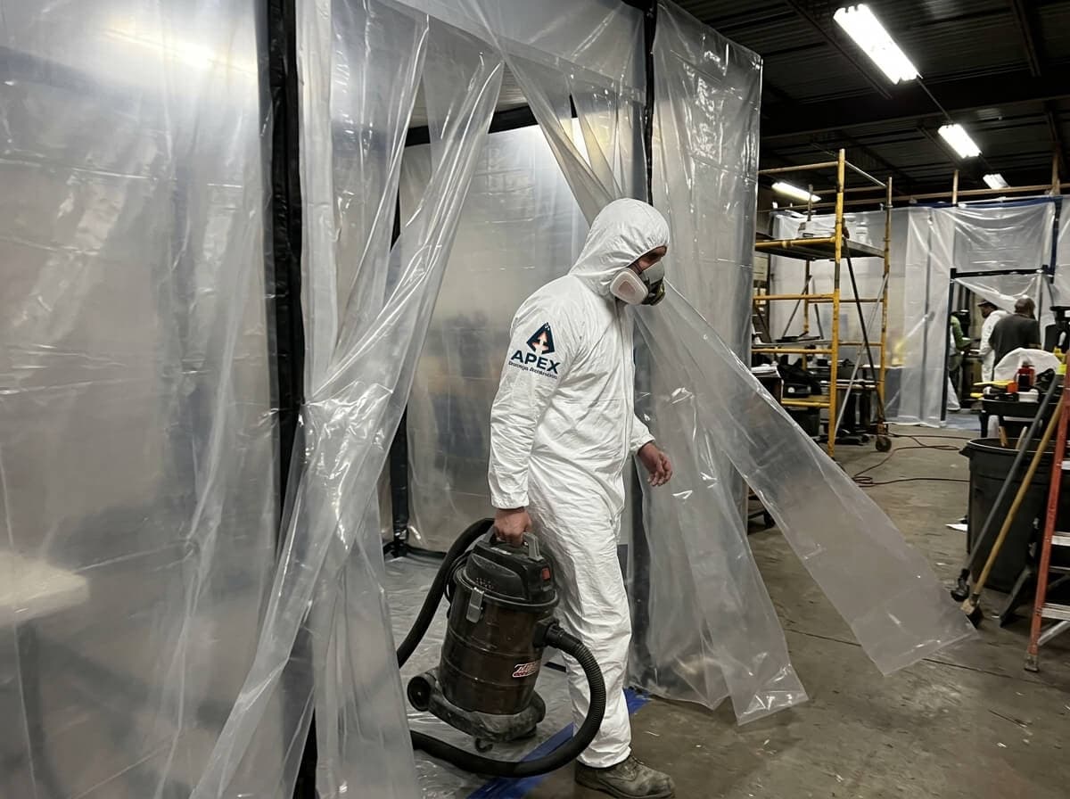 Asbestos Abatement Specialist Stepping Through Decontamination Chamber in Aurora CO